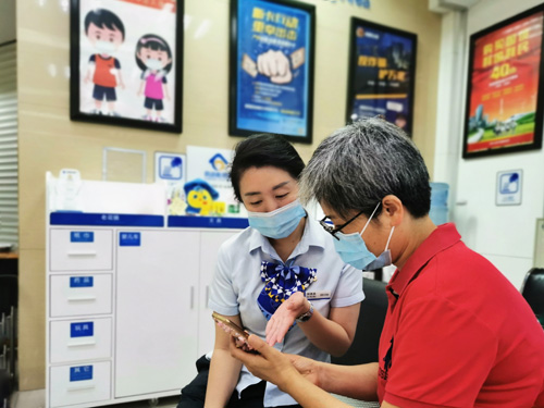 建行成都第六支行，大堂經(jīng)理為客戶介紹手機銀行&ldquo;大字&rdquo;模式